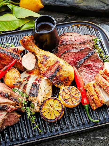 Grilled meats and vegetables on a platter at Walter Peak Gourmet BBQ Experience.