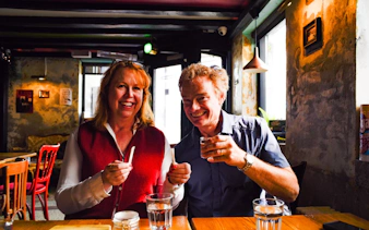 Couple enjoying Icelandic food tasting in Reykjavik café during punk music history tour.