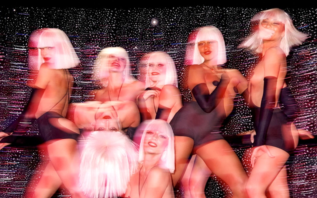 Performers at Crazy Horse show in Paris with vibrant lighting effects.