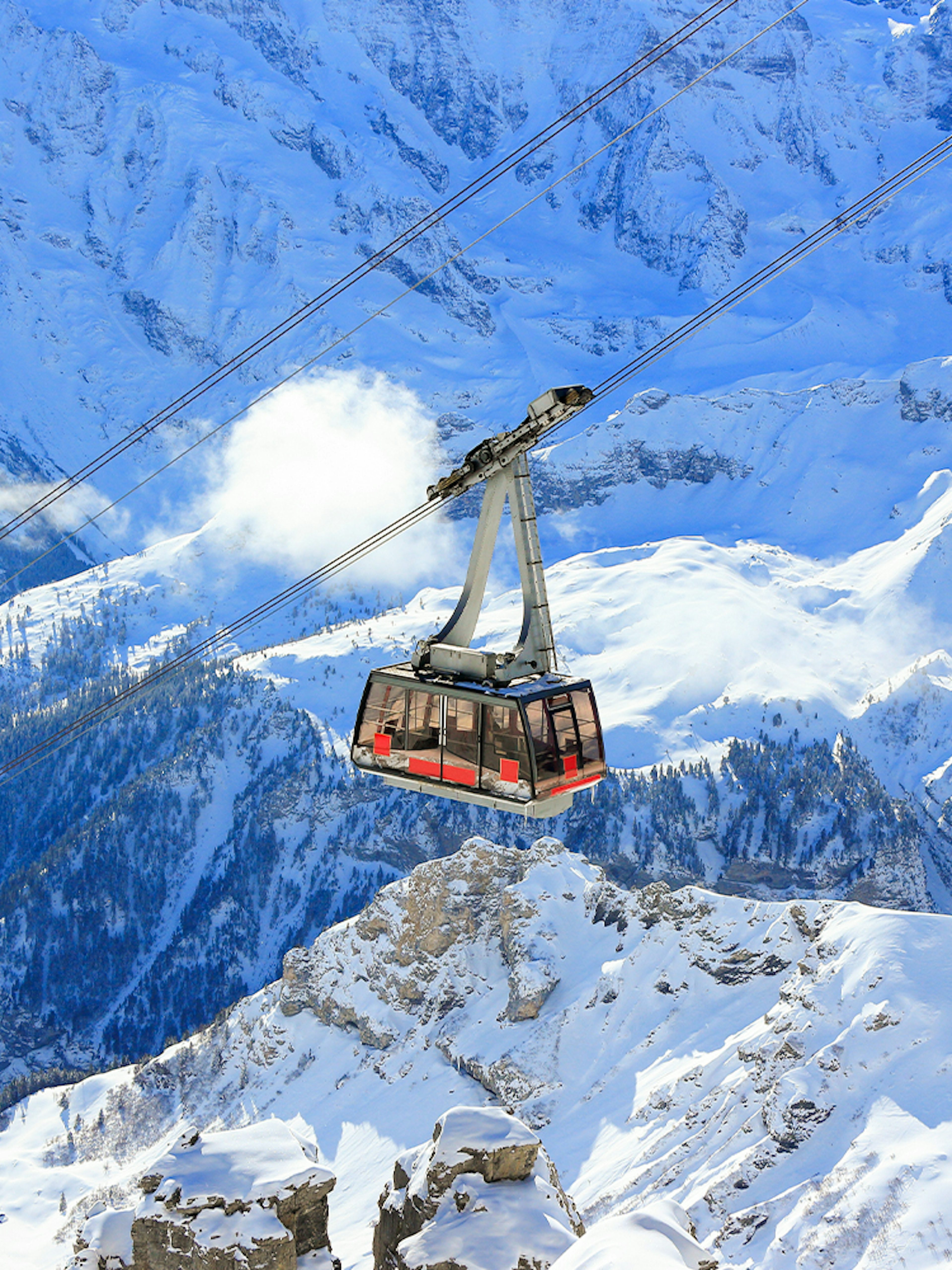 Cable car ascending snowy mountains to Schilthorn - Piz Gloria from Stechelberg.