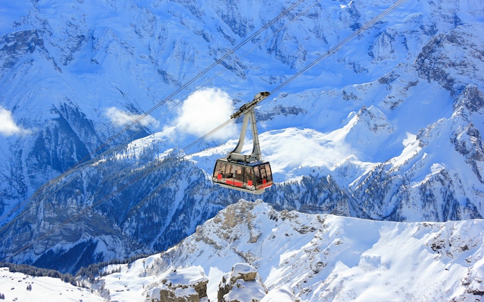 Cable car ascending snowy mountains to Schilthorn - Piz Gloria from Stechelberg.