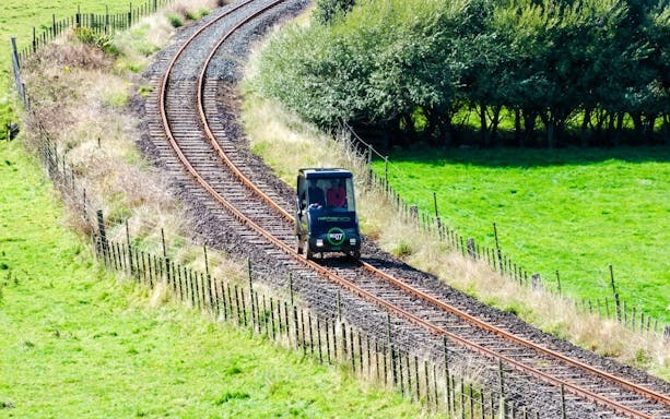 Self-drive rail car on a scenic track in Ngongotaha, surrounded by greenery.
