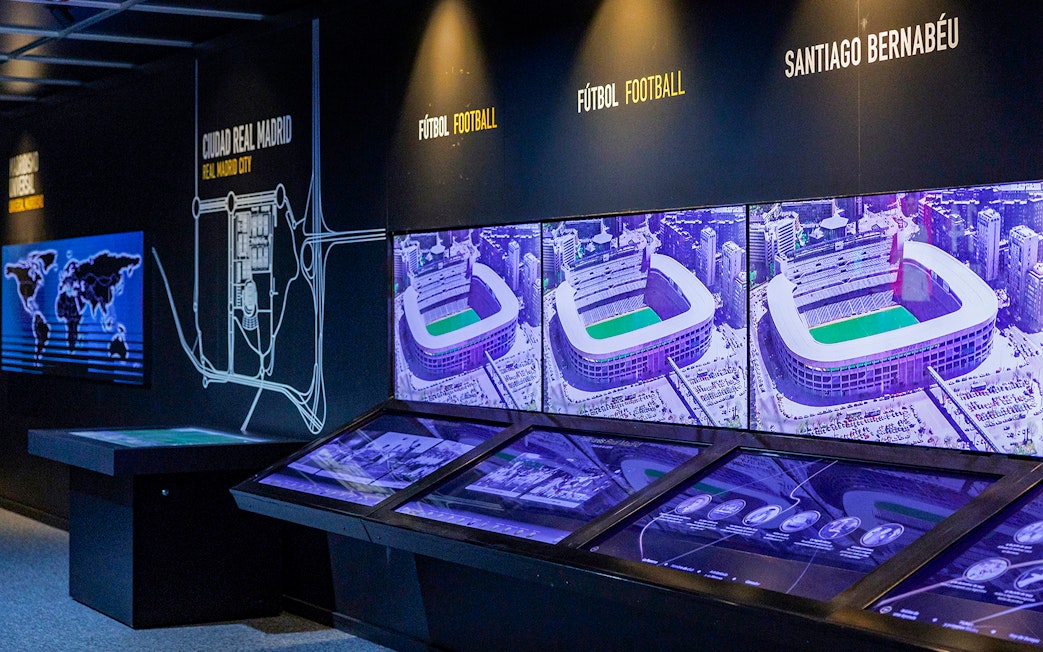 Interactive exhibit showcasing Santiago Bernabeu Stadium history with aerial images and maps.