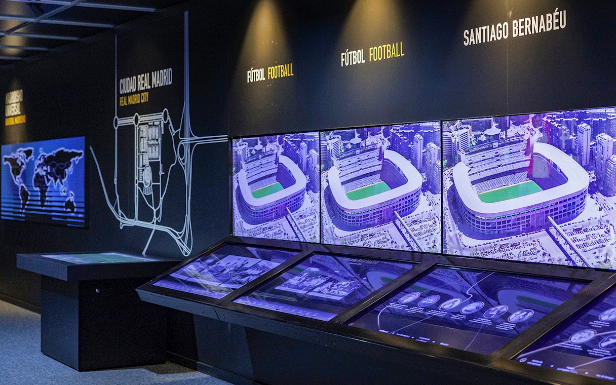 Interactive exhibit showcasing Santiago Bernabeu Stadium history with aerial images and maps.