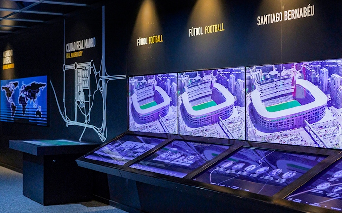 Interactive exhibit showcasing Santiago Bernabeu Stadium history with aerial images and maps.
