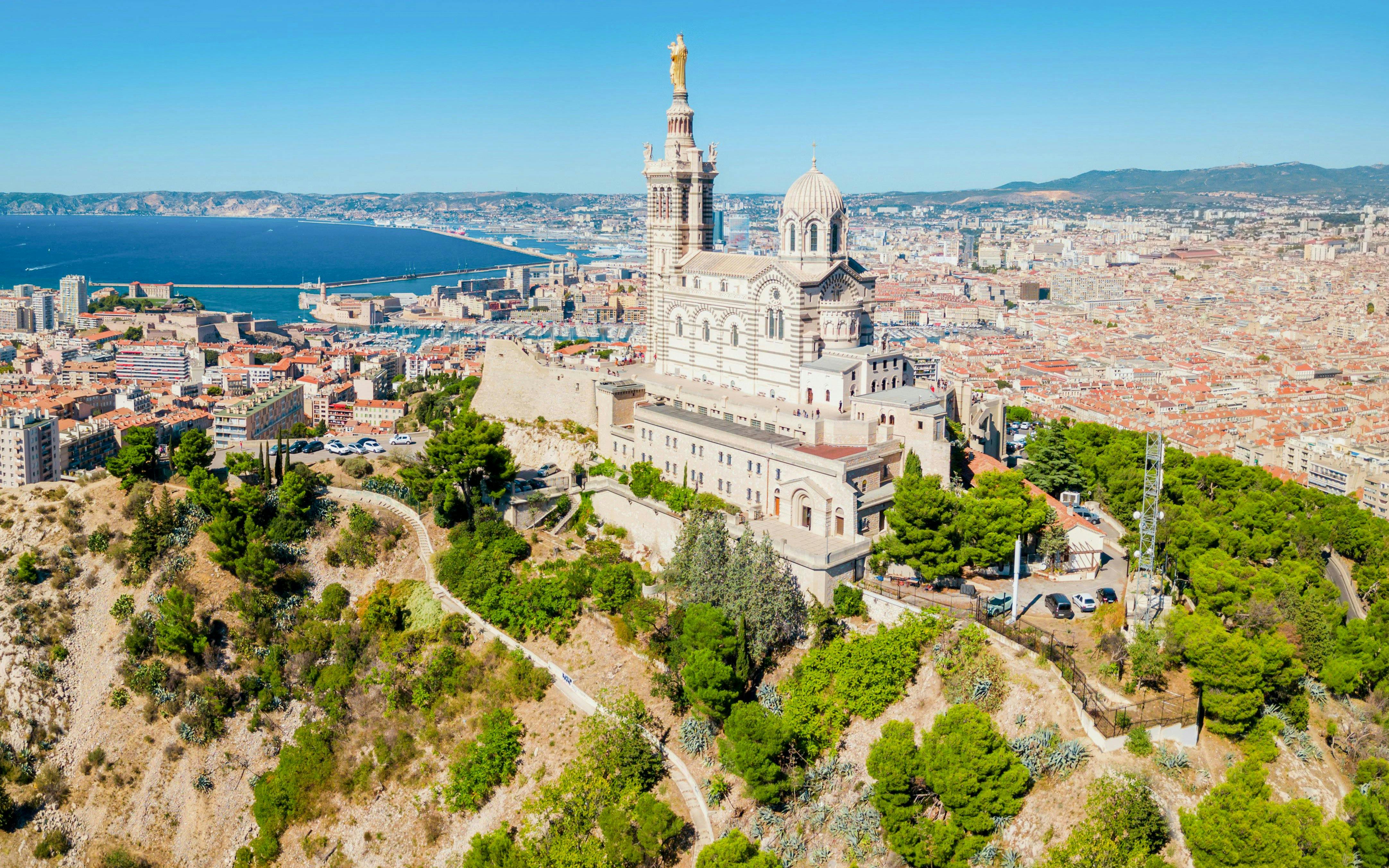 Notre Dame de la Garde overlooking Marseille cityscape and Mediterranean Sea.