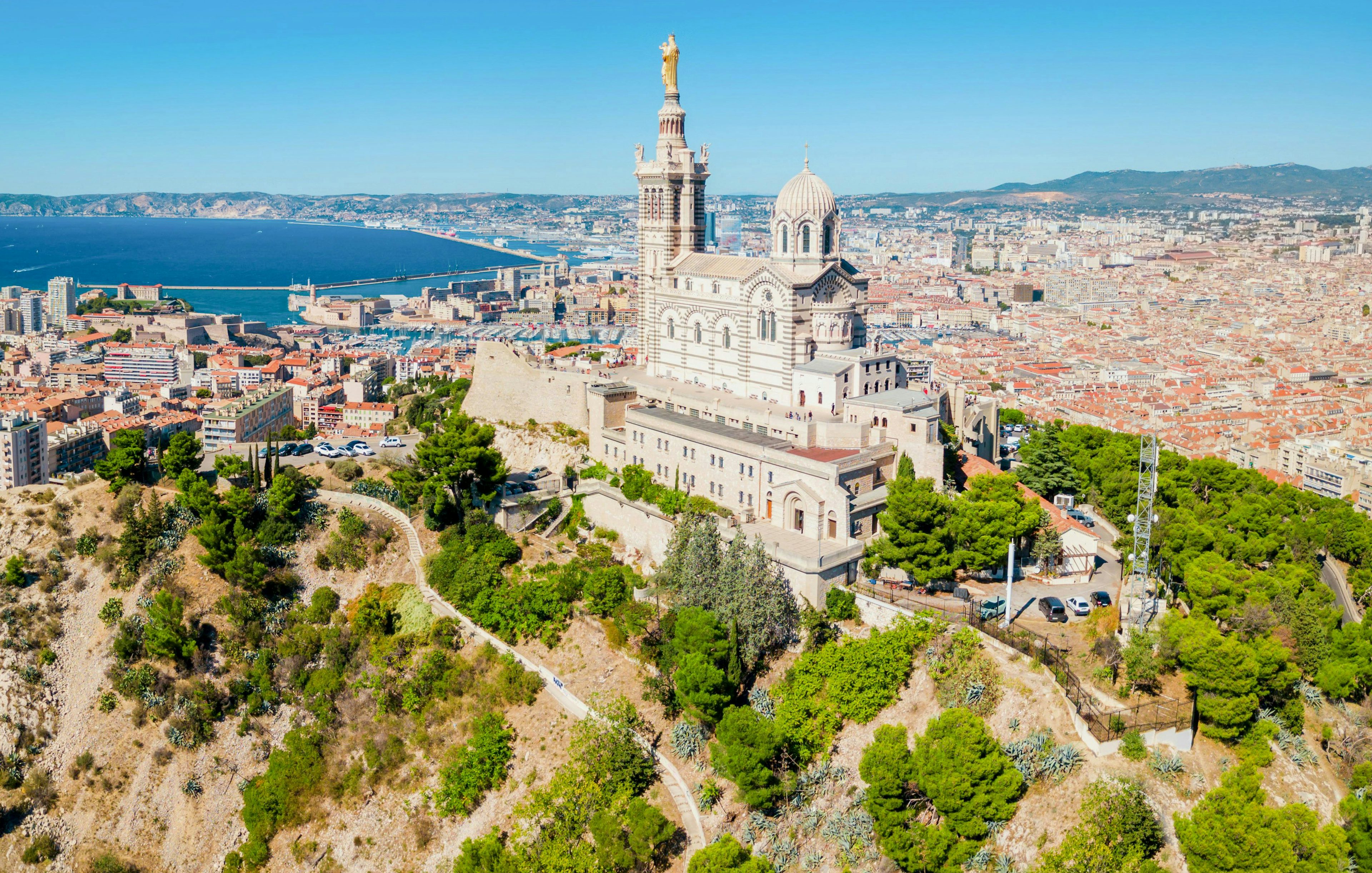 Notre Dame de la Garde overlooking Marseille cityscape and Mediterranean Sea.