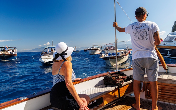 Couple enjoying boat tour near Capri with view of surrounding boats.