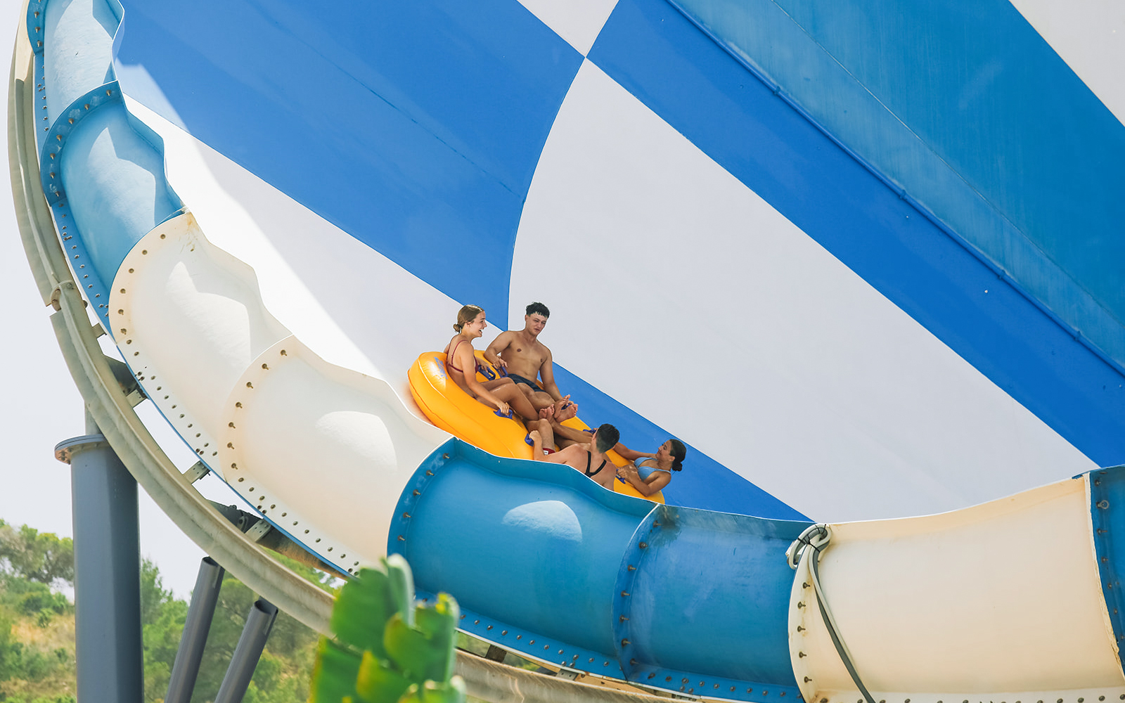 Group riding inflatable raft on Cyclon slide at Aqualandia Benidorm.