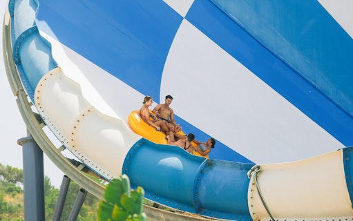 Group riding inflatable raft on Cyclon slide at Aqualandia Benidorm.