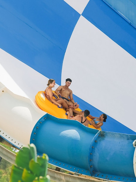 Group riding inflatable raft on Cyclon slide at Aqualandia Benidorm.