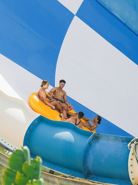 Group riding inflatable raft on Cyclon slide at Aqualandia Benidorm.