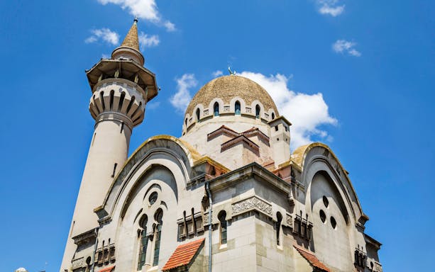 Constanta's Grand Mosque minaret and dome under blue sky.