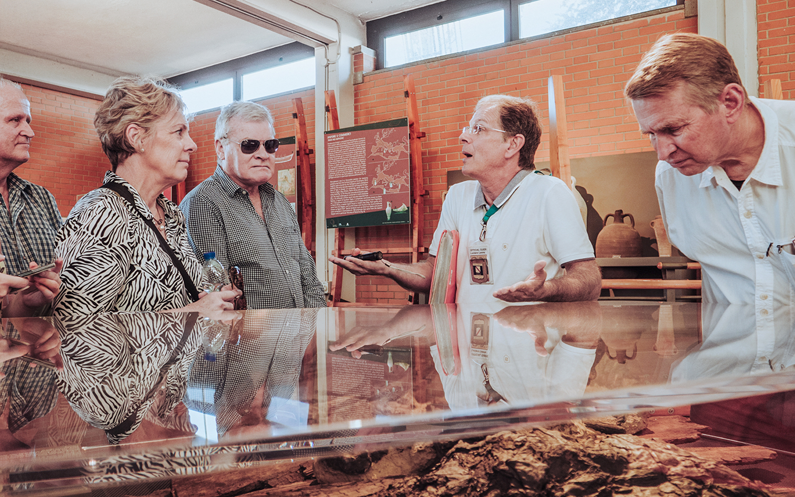 Tour guide discussing Herculaneum archives with visitors in a museum setting.