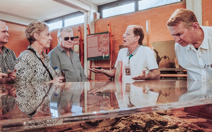 Tour guide discussing Herculaneum archives with visitors in a museum setting.