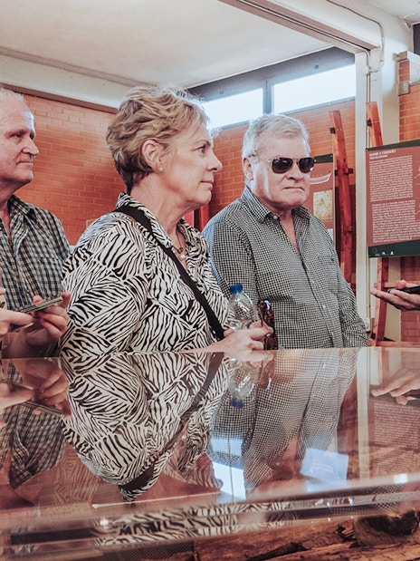Tour guide discussing Herculaneum archives with visitors in a museum setting.