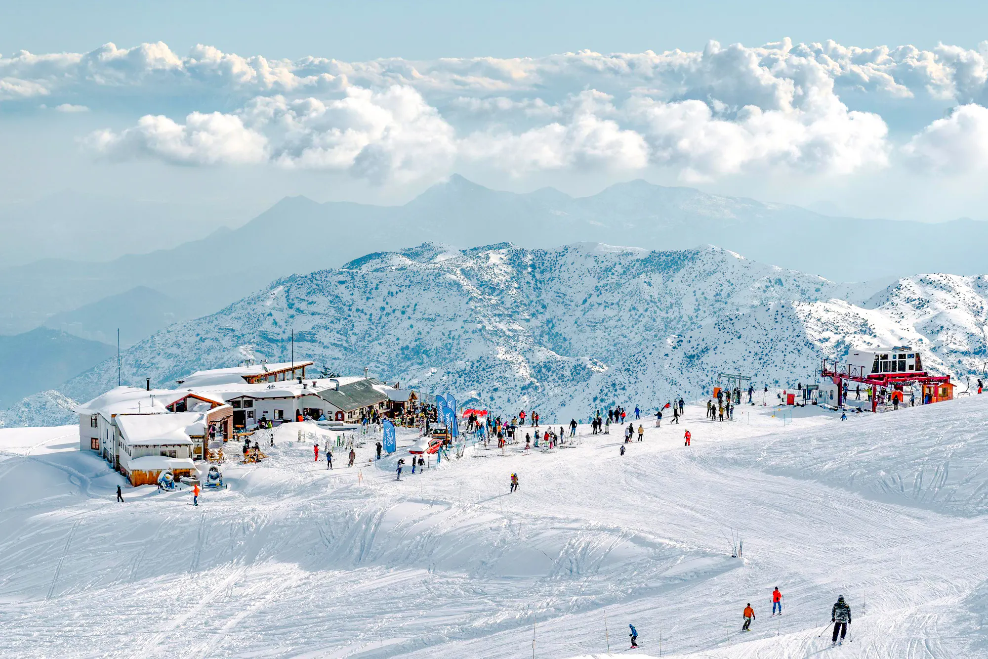 Farellones Park ski slopes with visitors, snowy Andes mountains in Santiago.