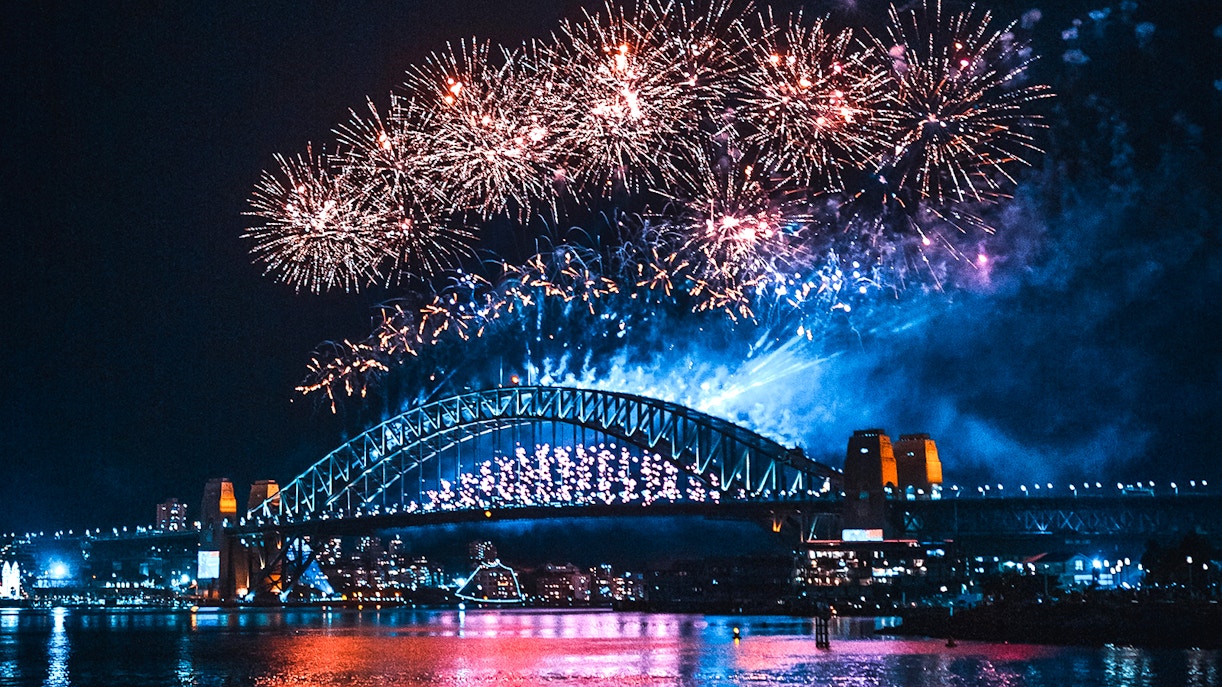 Fireworks over Sydney Harbour Bridge at night.