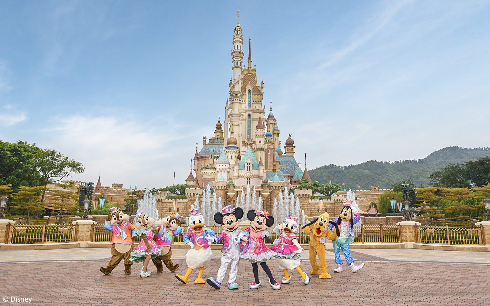 Disney characters celebrating 20th anniversary at Hong Kong Disneyland castle.