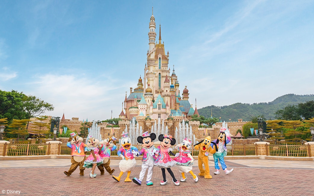 Disney characters celebrating 20th anniversary at Hong Kong Disneyland castle.