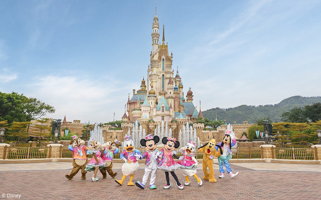 Disney characters celebrating 20th anniversary at Hong Kong Disneyland castle.