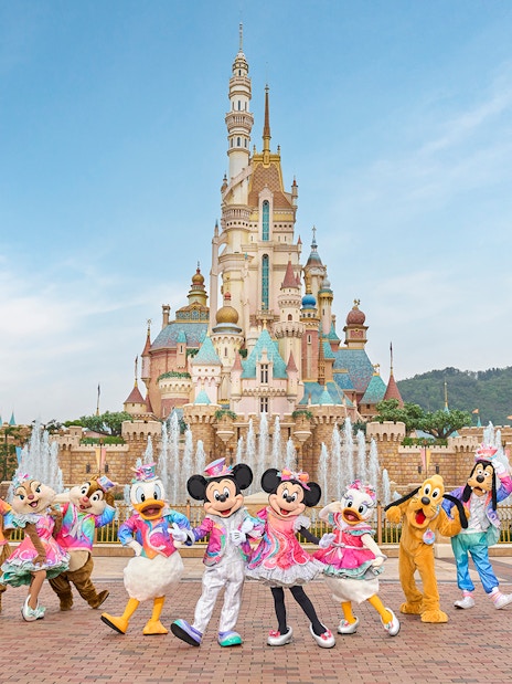 Disney characters celebrating 20th anniversary at Hong Kong Disneyland castle.