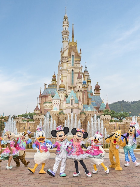 Disney characters celebrating 20th anniversary at Hong Kong Disneyland castle.