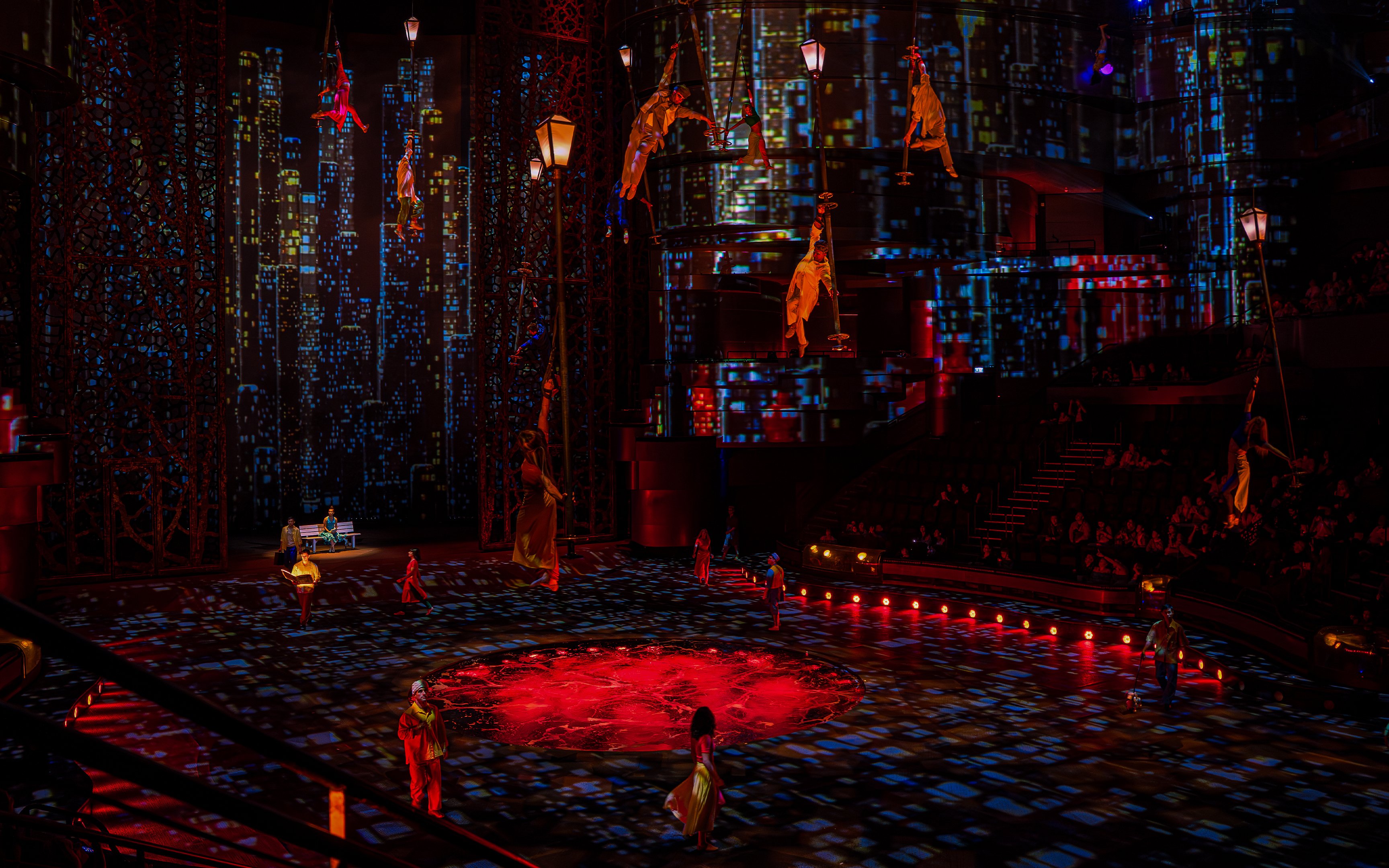 Acrobats performing at La Perle show in Dubai with vibrant cityscape backdrop.