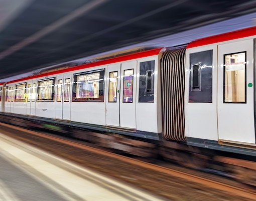 Barcelona metro train arriving at a station platform with passengers boarding.