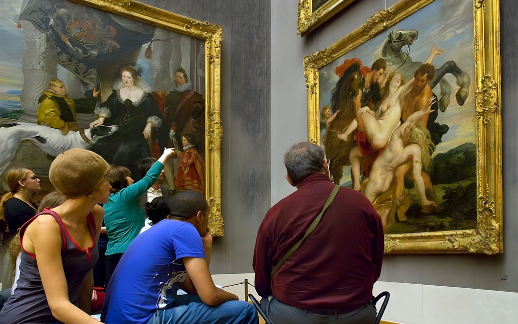Visitors viewing paintings at an art museum in Munich.