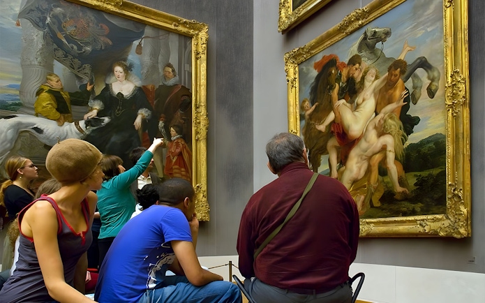 Visitors viewing paintings at an art museum in Munich.