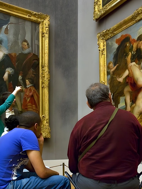 Visitors viewing paintings at an art museum in Munich.