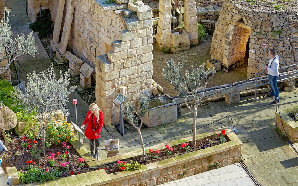 Ancient stone ruins with visitors exploring the Prehistoric Temples in a guided tour.