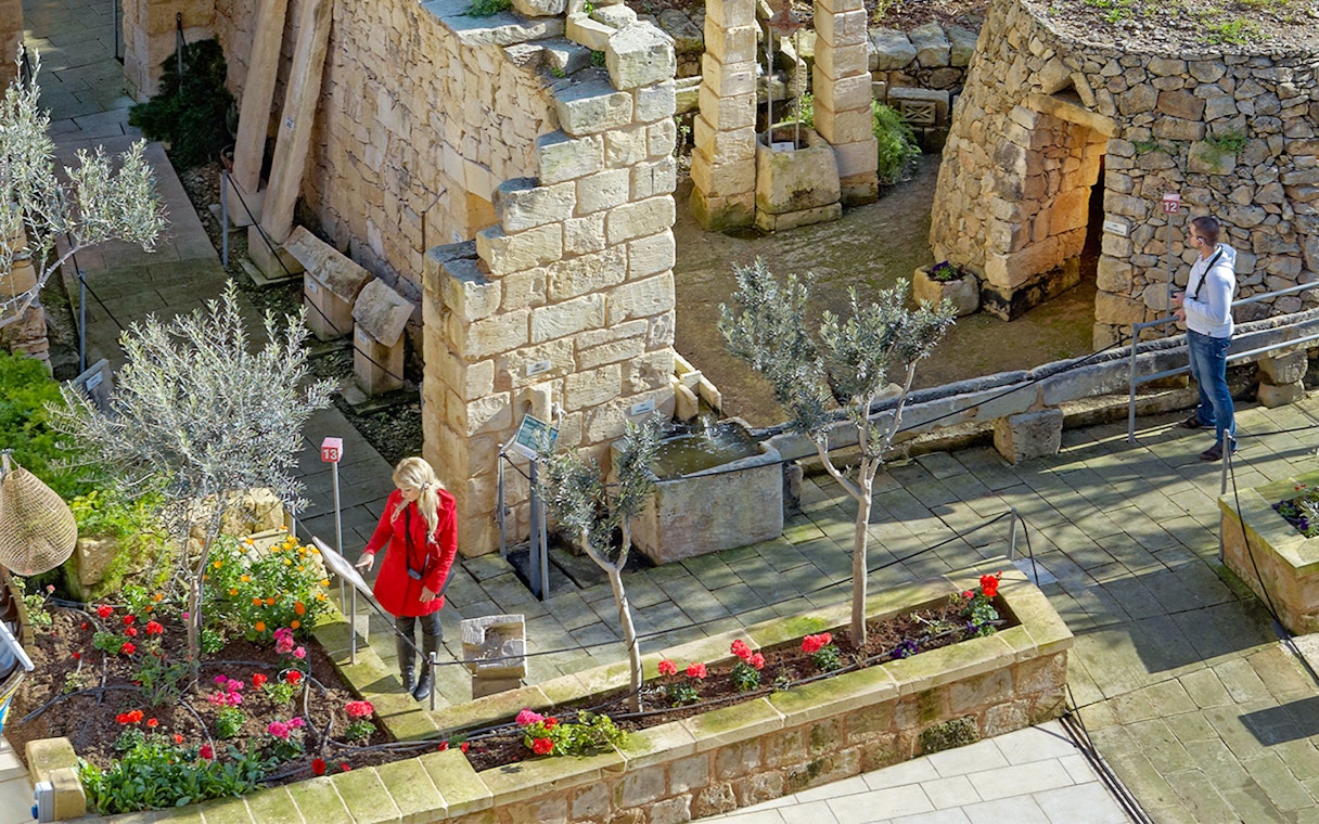 Ancient stone ruins with visitors exploring the Prehistoric Temples in a guided tour.