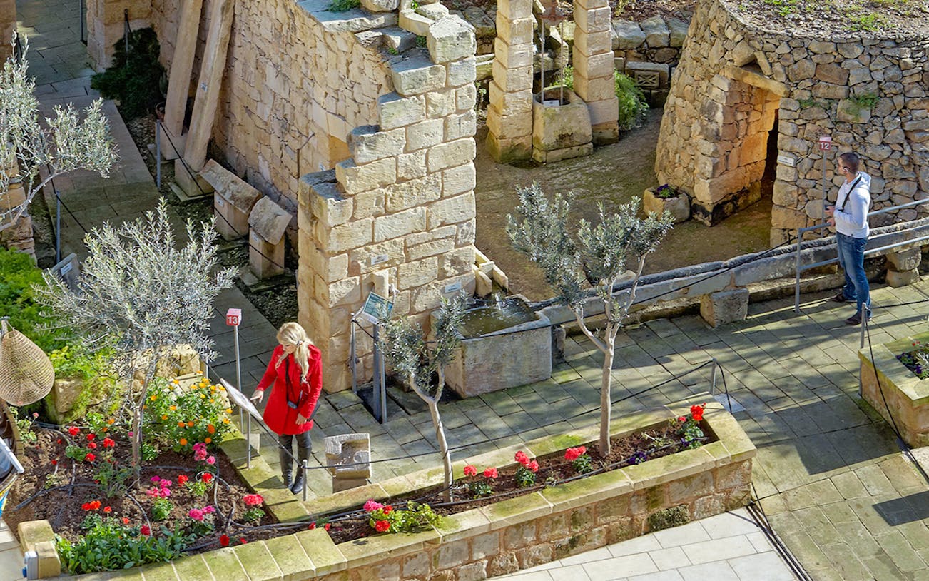 Ancient stone ruins with visitors exploring the Prehistoric Temples in a guided tour.