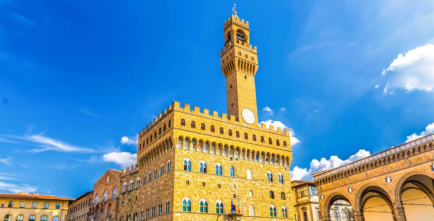 Palazzo Vecchio Museum with clock tower under blue sky in Florence, Italy.