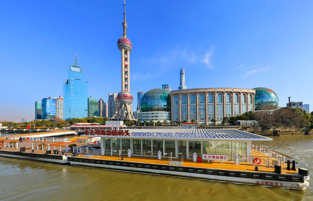 Oriental Pearl Cruise Terminal on Huangpu River with Shanghai skyline in background.