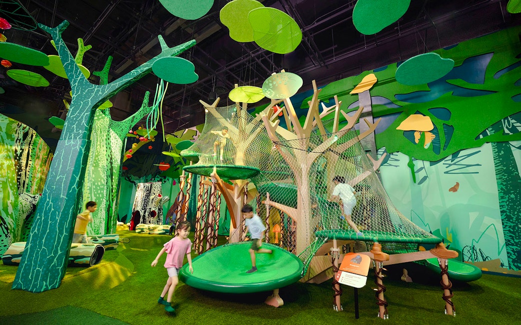 Children playing on a jungle-themed climbing structure at Forestland Orangutan Platform.