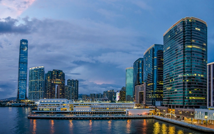 Hong Kong skyline at dusk during AquaLuna Harbor day tour.