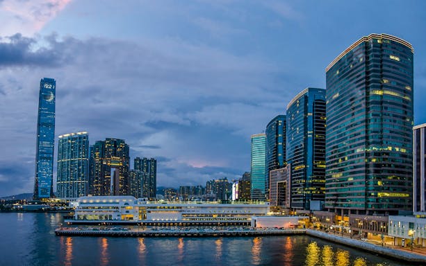Hong Kong skyline at dusk during AquaLuna Harbor day tour.