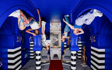 Visitors hanging upside down in the Royal Room at the Upside Down Amsterdam.