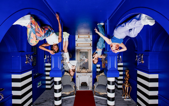 Visitors hanging upside down in the Royal Room at the Upside Down Amsterdam.