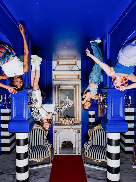 Visitors hanging upside down in the Royal Room at the Upside Down Amsterdam.