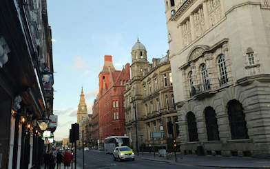 Street view of historic buildings in Liverpool, featuring a clock tower, part of the Murder Mystery city exploration game.