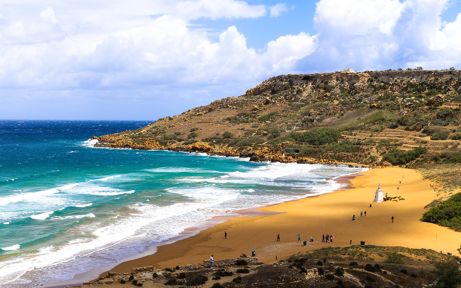 Ramla Bay Malta with golden sand and turquoise water, surrounded by lush hills.