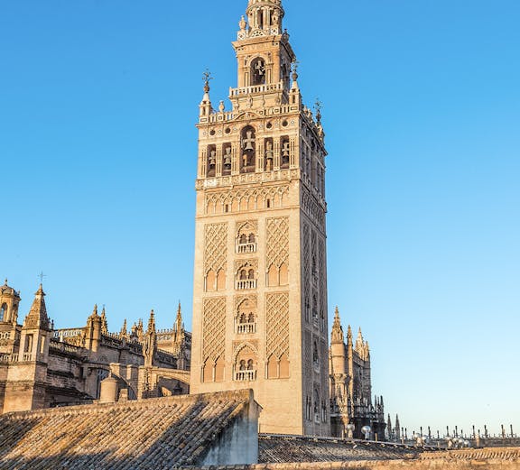 La Giralda tower in Seville, Spain, against a clear blue sky.