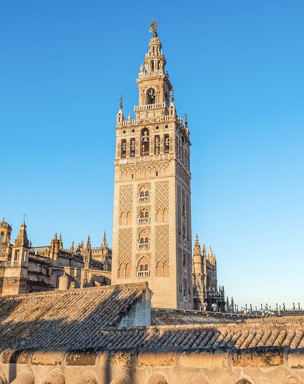La Giralda tower in Seville, Spain, against a clear blue sky.