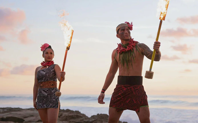 Performers with torches at sunset during Kaula-Luau in Hawaii.