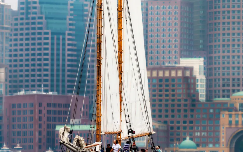 Liberty Star sailing in Boston Harbor with city skyline in background.