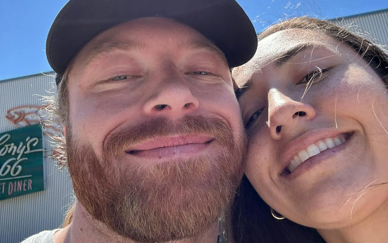 Selfie of two people smiling in front of a diner sign during Seattle city exploration game.